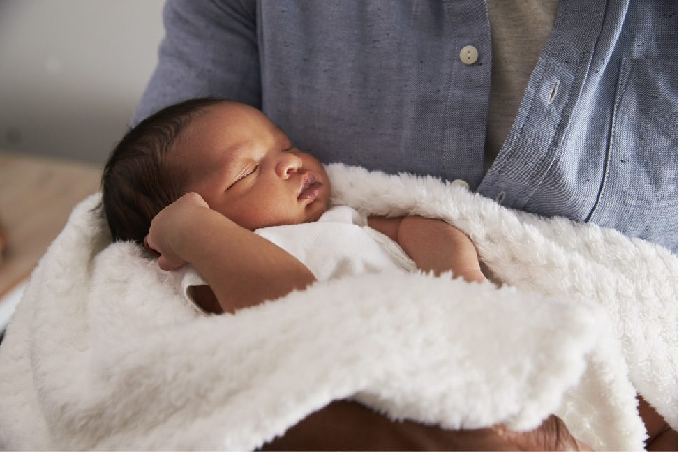 Sleeping baby in adult arms