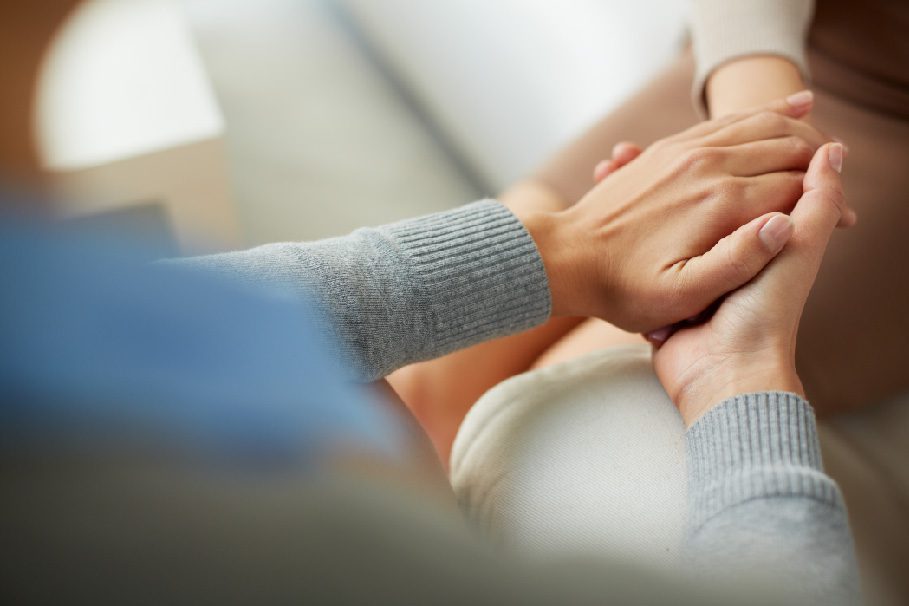 Closeup of hands giving comforting touch